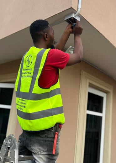 Sunnovate technician installing a CCTV camera on a building exterior