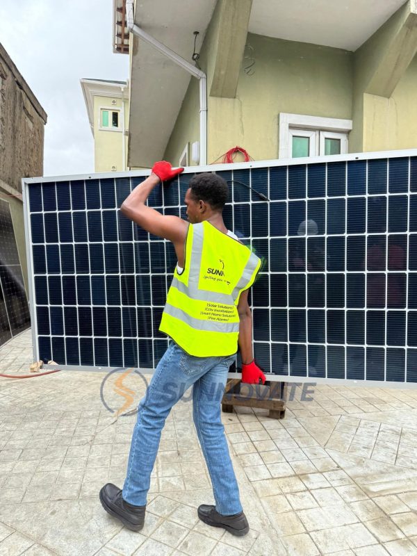 Sunnovate engineer carrying a solar panel on site